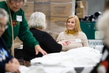 Renee works with others to prepare items for shoebox gifts that arrive at the processing center partially full.