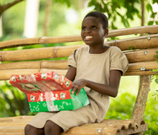 Josephine enjoys the special gifts she received during a shoebox gift distribution in Togo.