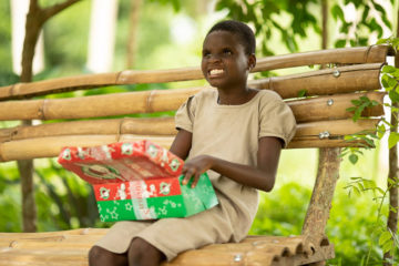 Josephine enjoys the special gifts she received during a shoebox gift distribution in Togo.