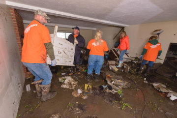 Volunteers have to carry away debris and ruined belongings from flooded Nebraska homes.