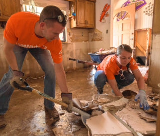 Volunteers shovel out waterlogged debris from the flooded home of Chester McLaughlin in Sand Springs, Oklahoma, where more than 1,000 homes were flooded last week.