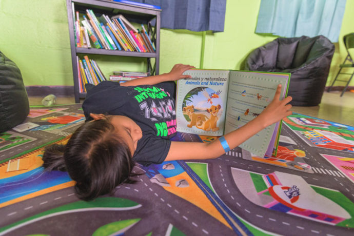 A young girl takes a moment to rest and read at Good Samaritan Migrant respite center before she and her family begin the next leg of their journey to a host.
