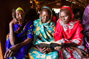 Women read the sermon text during a Sunday morning worship service. 