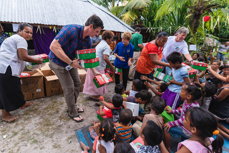 Edward Graham ayuda a distribuir cajas de regalos durante un evento evangelístico en las aldeas locales.