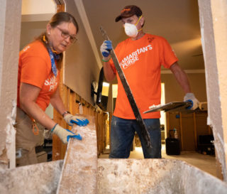 Volunteers work hard to mud out a home that was flooded in Winnie, Texas.