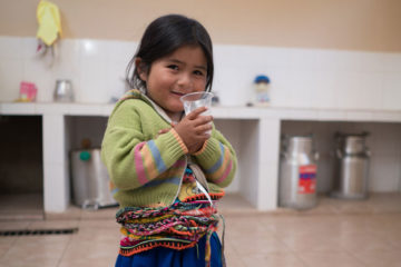 Maria enjoys freshly pasteurized milk at the dairy processing center.