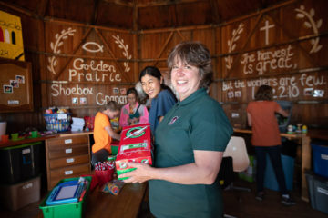 Jana Ginter and Pawku Ju help prepare shoeboxes in the converted granary.