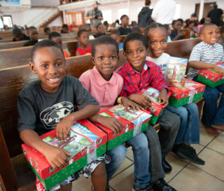 Boys wait eagerly to open their gift-filled shoeboxes on the pews of a church in the Bahamas.