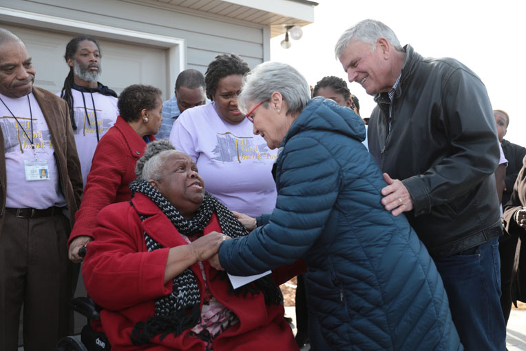 Franklin and Jane Graham greet Earnestine Reese at the home dedication on Dec. 20.