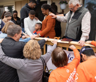 Samaritan's Purse staff and volunteers pray over the newly-rebuilt home of Army Sergeant Anthony and Kenyatta James in New Bern, North Carolina.