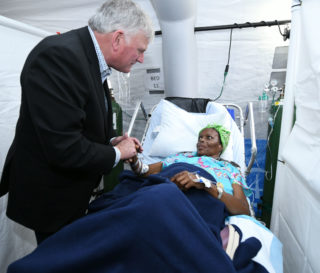 Franklin Graham visits with a patient at the Emergency Field Hospital set up by Samaritan's Purse in the Bahamas.