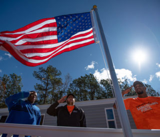 Members of Team Patriot join homeowner Chris Holmes in raising and honoring the American flag. This flag was given to the former Marine by Samaritan's Purse.