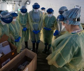 Medical staff prays in Italy.