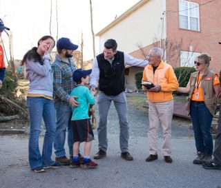 Edward Graham and Samaritan's Purse volunteers pray with homeowners, the Scarfia family and Canh Dang Duc.