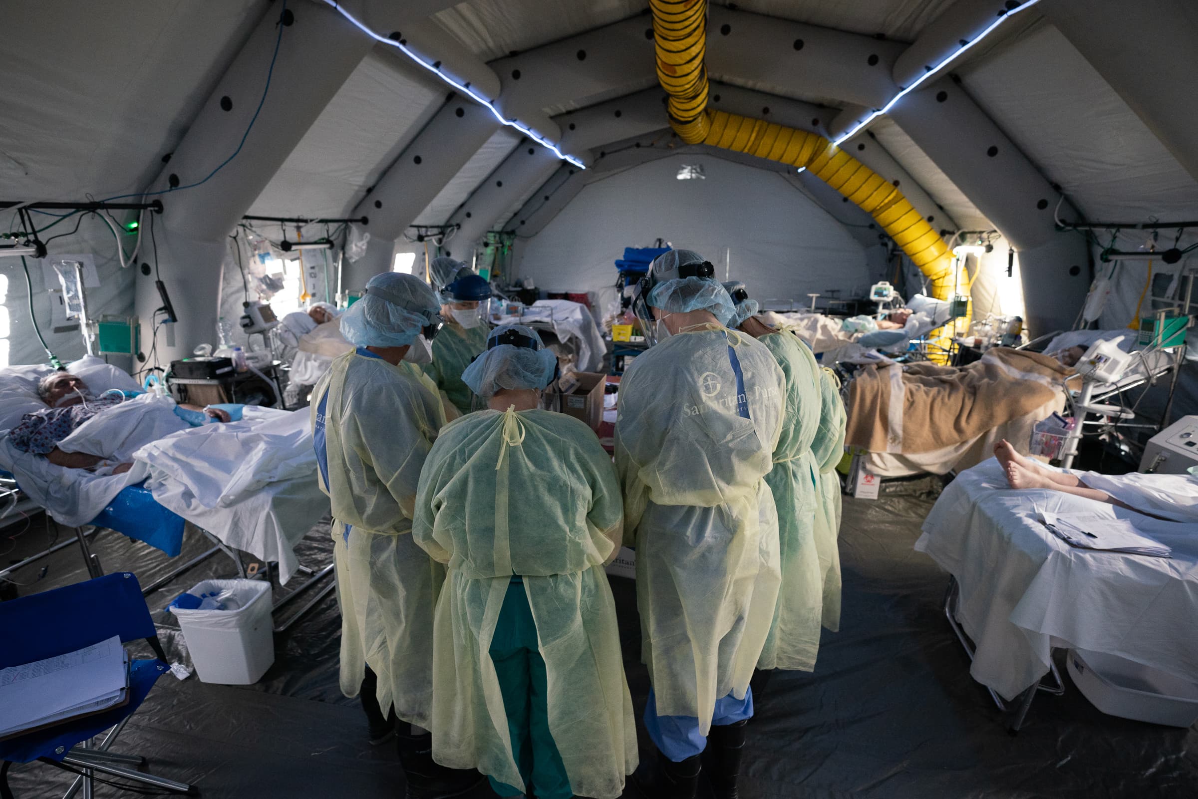 Doctors and nurses take time to pray together for their patients in the field hospital.