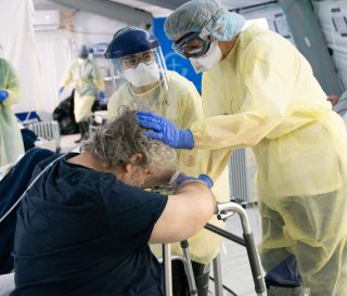 Dr. Julie McKay prays for Umberto after his transfer from the ICU, where he was on a ventilator for more than two weeks.