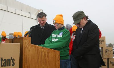 Lesley Clementi flanked by Franklin Graham (left) and musician Bono (right) pray during a special send-off for Operation Christmas Child shoebox gifts being airlifted to Uganda.