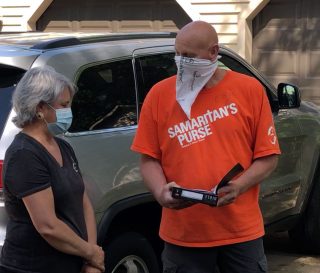 A volunteer presents a homeowner with a special Billy Graham Study Bible signed by the team.