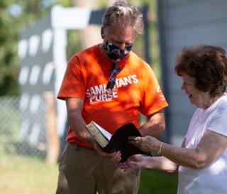 Volunteers presented homeowner Della Ramsey with a Billy Graham Study Bible signed by the team after clean up work was completed at her house.
