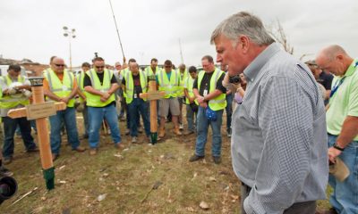 Franklin Graham prays with workers in Moore, Oklahoma, who had erected crosses in memory of seven children killed in the storm.