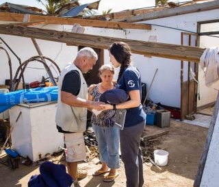 Our team prays with a woman in the aftermath of Typhoon Yutu.