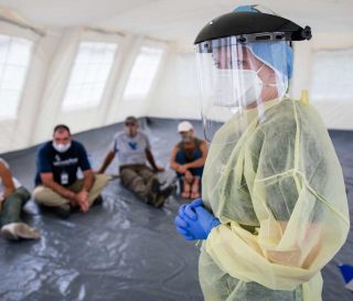 Donning PPE to prepare for EFH in Nassau