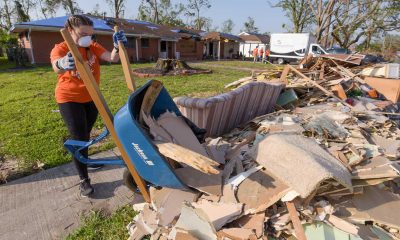 Woman working to clear debris after hurricanes in Louisiana.