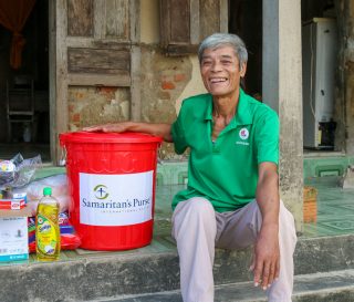 Hop, a beneficiary in Vietnam receives, relief supplies from Samaritan's Purse.