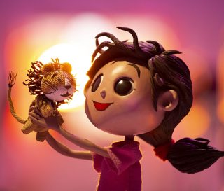 Lola's Lion film image: Girl holding a stuffed lion.