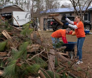 Volunteers remove debris from the home of Samuel and Khristy Wilkins.