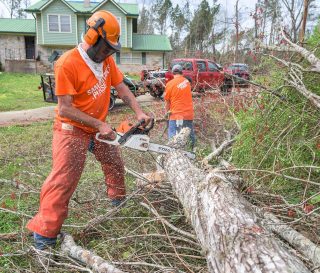 Volunteers cut up and haul away downed trees near Gadsden, Alabama.