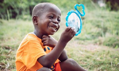 Emmanuel has a hard time not looking at his miraculously new lip after cleft lip surgery at ELWA.