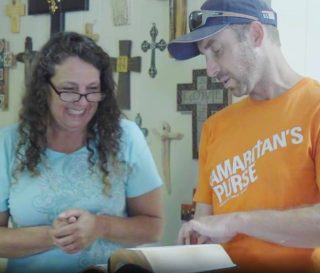 Samaritan's Purse volunteer presents Bible to homeowner