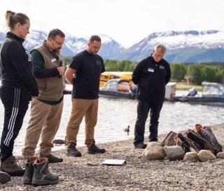 Trish Dawson joins her husband and our chaplains in prayer being baptized in Lake Clark.