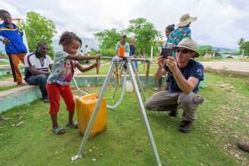 Dano's daughter collects water from the new tap stand installed by Samaritan's Purse.