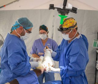 A Samaritan's Purse surgical team bandages an injured leg following surgery to save the limb.