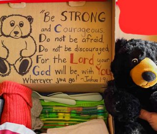 Theresa Bell themed this shoebox around camping with a picture of a deer on the outside and a stuffed bear, an animal t-shirt, and a water bottle inside.
