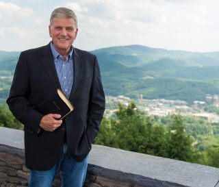 Franklin Graham holding a Bible and smiling