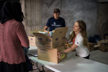 Michelle Mcilveen helps distribute relief items to a mother in need.