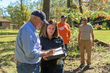 Mike and Karen Pence join other volunteers in signing a Bible for the homeowners.