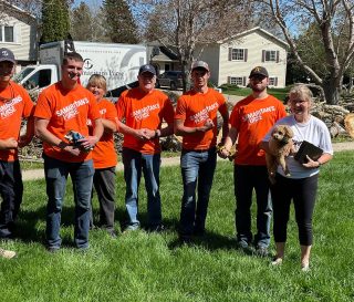 Volunteers meet with a homeowner after working on wind-damaged properties in South Dakota.