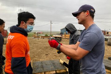 Corey Lynch, derecha, director de Alaska Projects, ayuda a preparar al equipo para construir los cimientos.