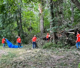 Los voluntarios quitan los árboles y los escombros del patio de Jaime and Chris Richardson en Fort Wayne, Indiana.