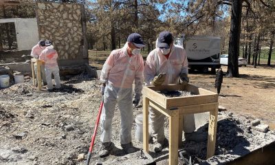 Volunteers sift through the rubble and ashes on a property near Mora, New Mexico.