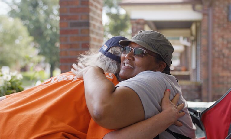 Helping homeowners in St. Louis County, Missouri. Volunteer gives homeowner a hug.