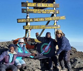 The Cooks reach the top of Mt. Kilimanjaro, highest peak in Africa.