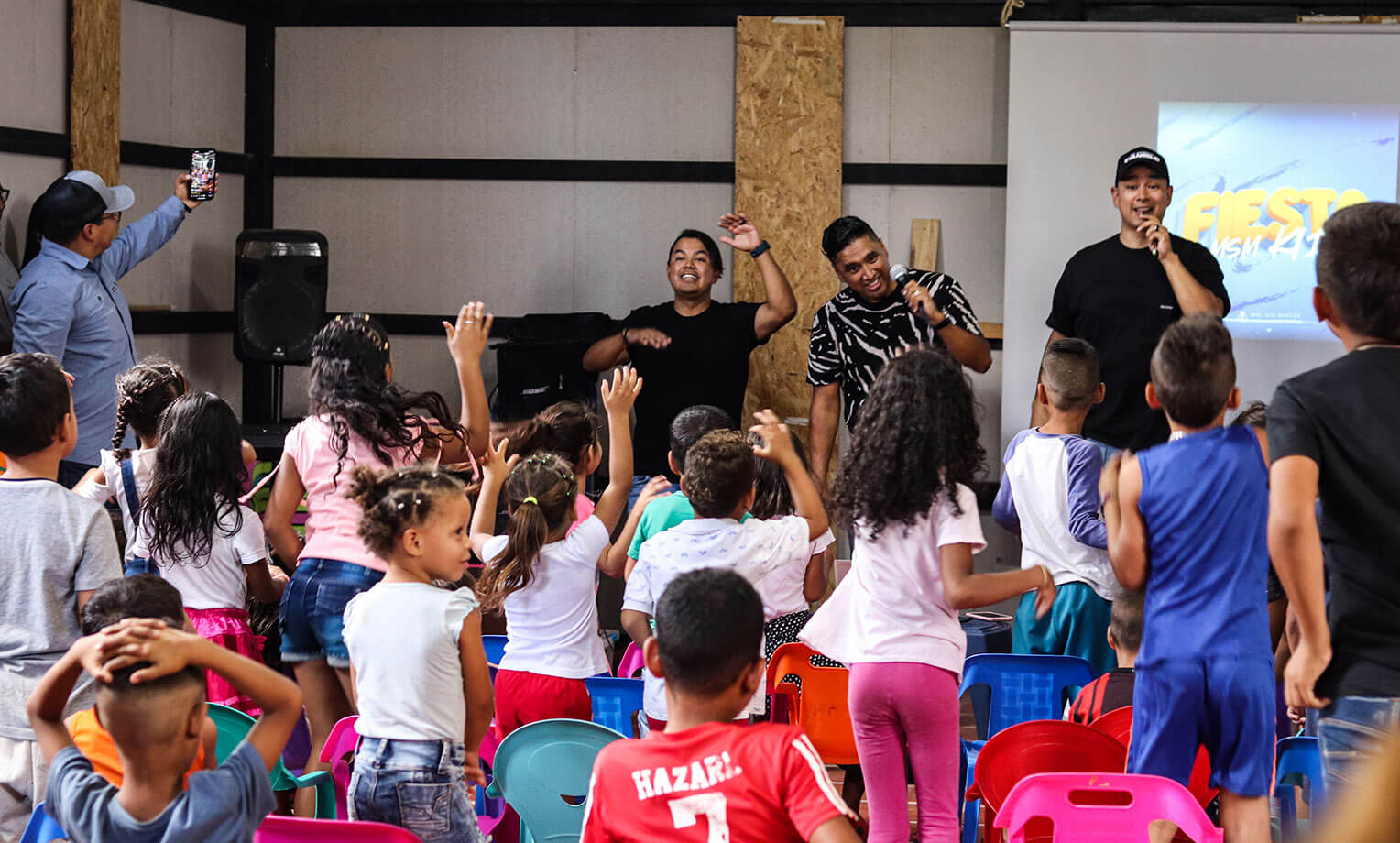 Miel San Marcos dirige el canto entre los niños en una comunidad migrante. 