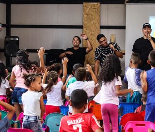 Miel San Marcos leads singing among children in a migrant community.