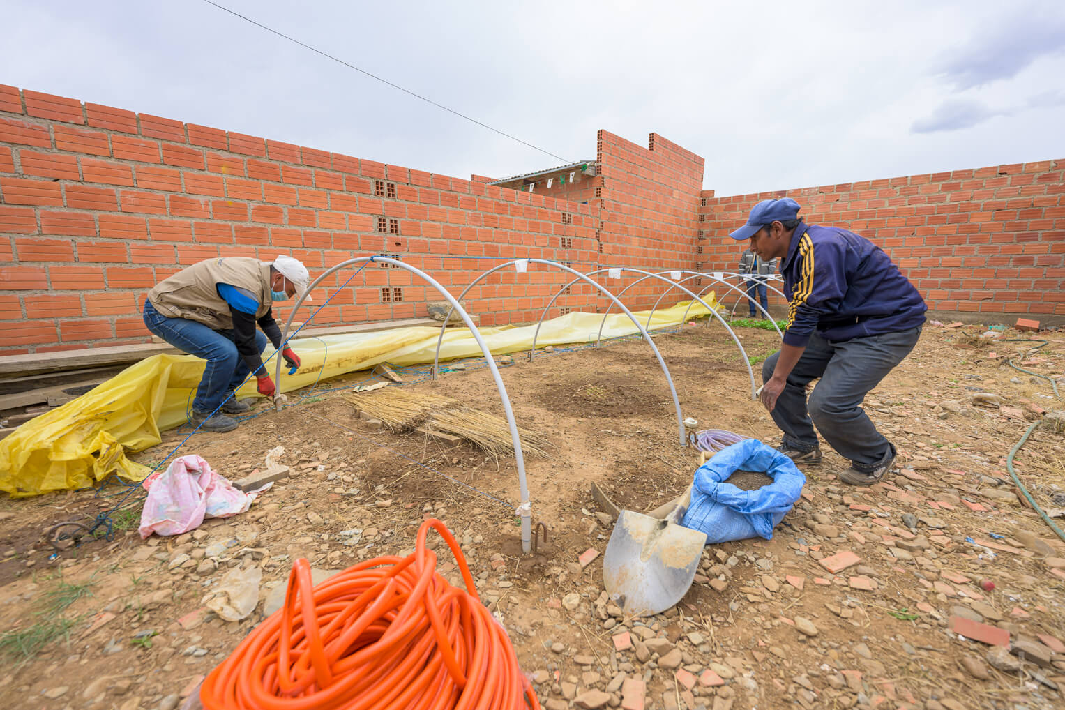 Franz, un residente en El Alto, ayuda a nuestro personal a construir micro-túneles para otros que quieren sembrar jardines en la ciudad.