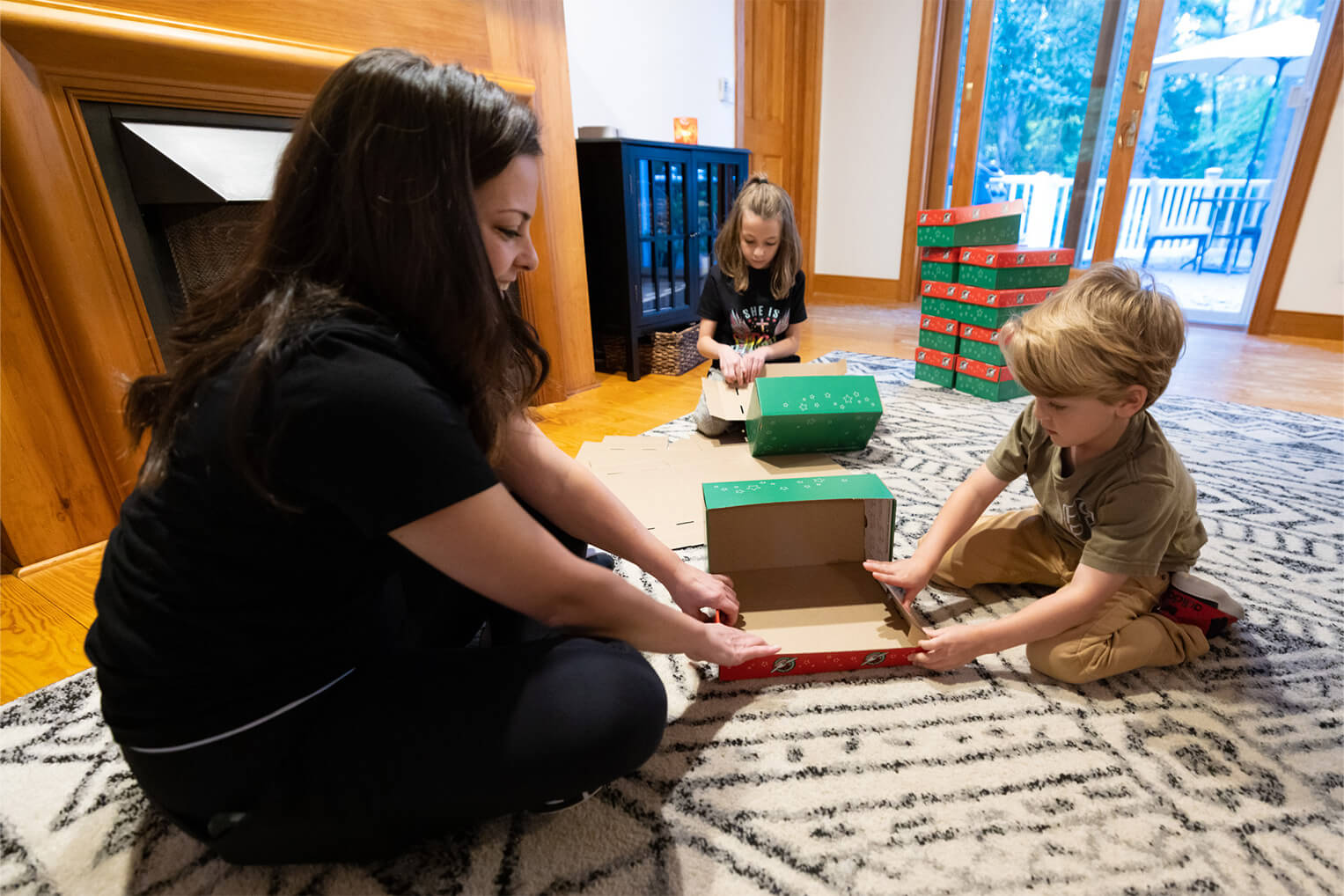 Ava's mother, Danielle, and brother, Jack, pack the shoebox gifts together.
